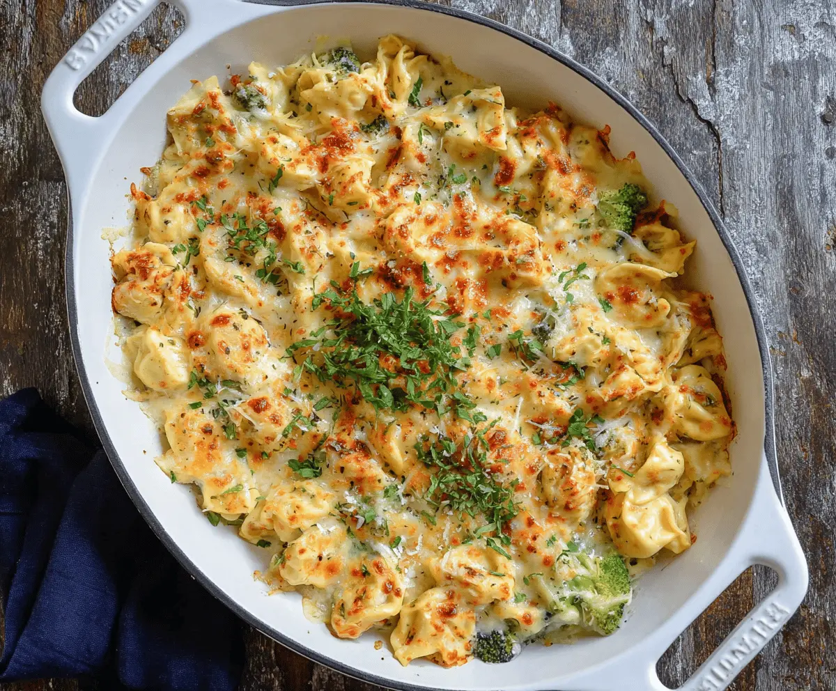 Creamy Alfredo Tortellini Bake topped with melted cheese and fresh herbs, served in a baking dish.