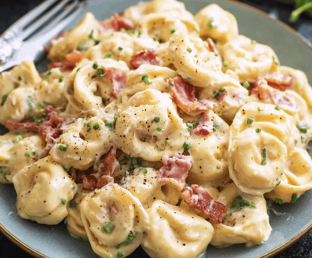 Creamy tortellini pasta with crispy pancetta and grated Parmesan cheese, served in a rich carbonara sauce