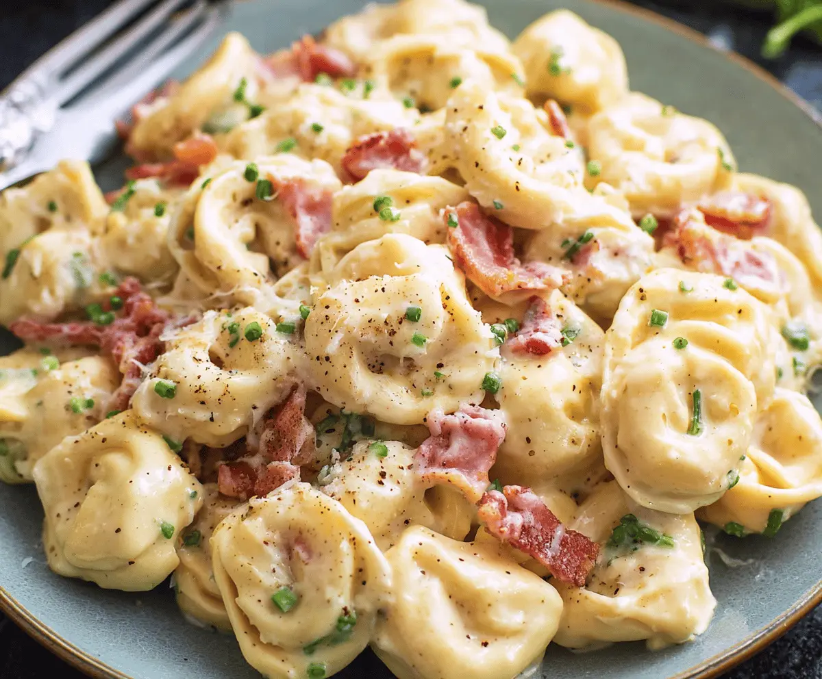 Creamy tortellini pasta with crispy pancetta and grated Parmesan cheese, served in a rich carbonara sauce