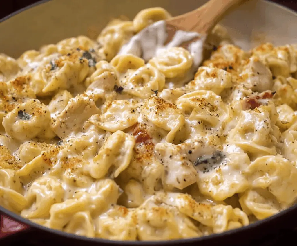 Creamy Garlic Parmesan Chicken Tortellini served with fresh herbs and grated cheese on a white plate