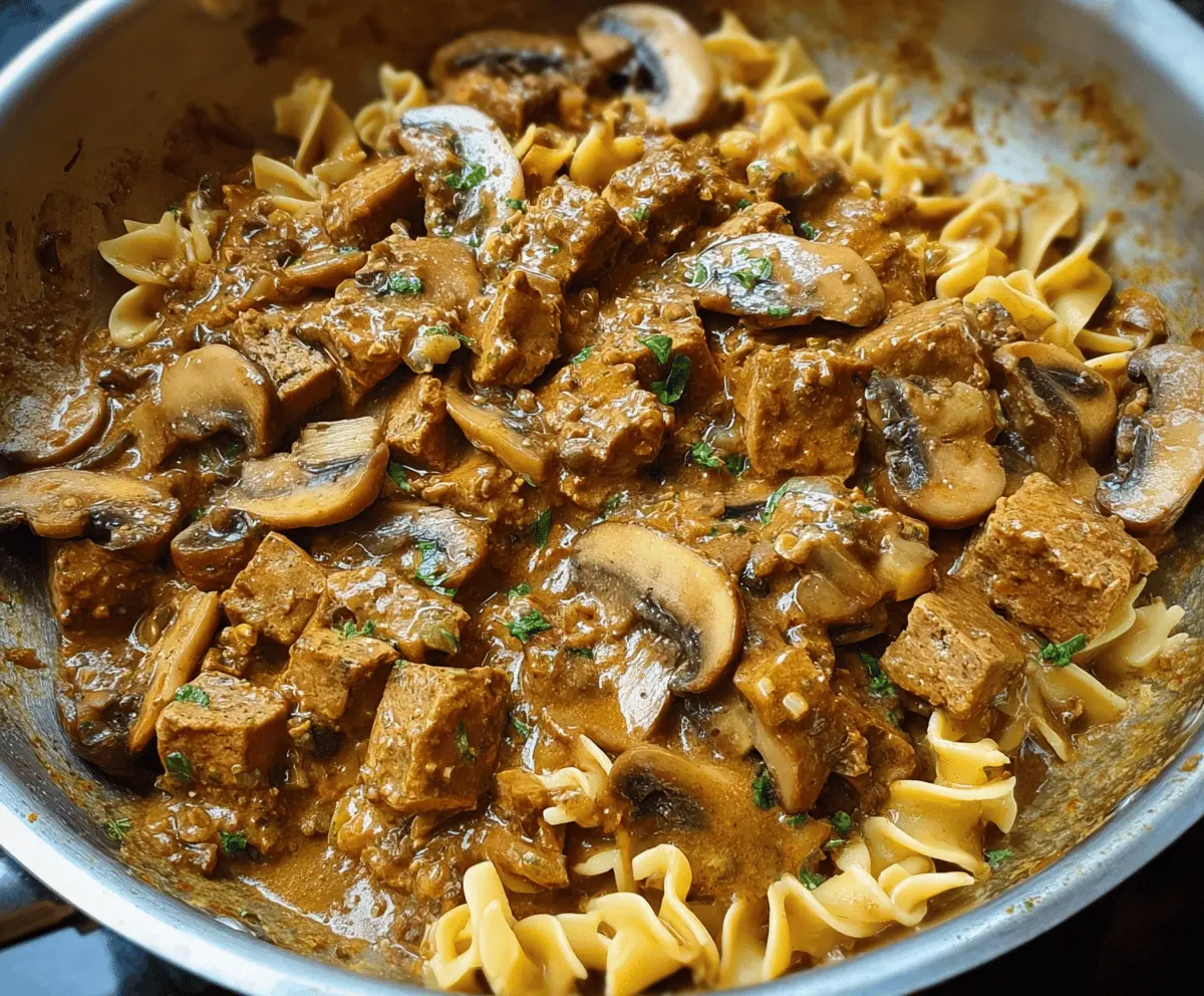 Creamy mushroom and seitan stroganoff served in a bowl, garnished with fresh herbs, perfect for a hearty vegetarian meal.
