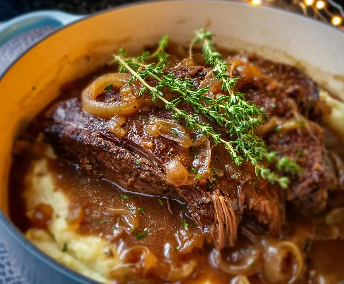 Delicious French onion pot roast with caramelized onions and tender beef served in a rustic bowl.