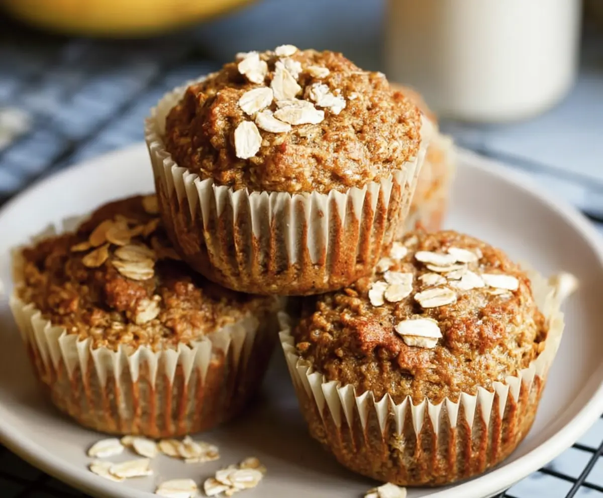 Freshly baked healthy banana oatmeal muffins stacked on a plate, perfect for a nutritious snack or breakfast.